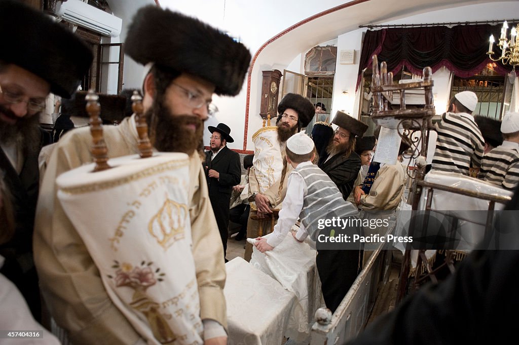 An Ultra-Orthodox Jew holds a Torah during the celebration...