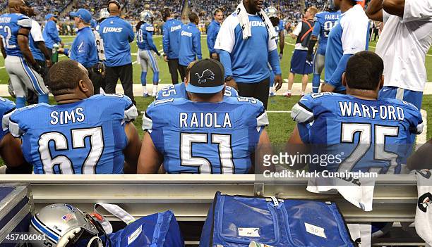 Rob Sims, Dominic Raiola and Larry Warford of the Detroit Lions sit together on the sidelines during the game against the Green Bay Packers at Ford...