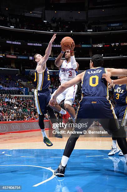 Chris Paul of the Los Angeles Clippers shoots against Gordon Hayward and Enes Kanter of the Utah Jazz during the game on October 17, 2014 at the...