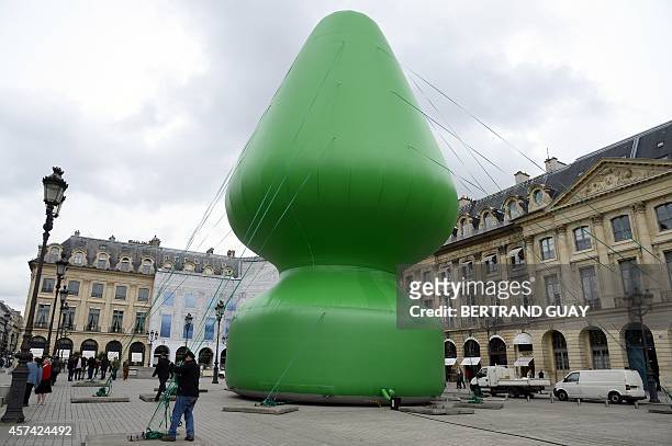 Picture taken on October 15, 2014 shows a 24-meter-high inflatable sculpture, called "Tree", by US artist Paul McCarthy on the Place Vendome in...