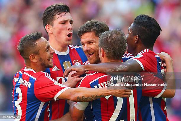 Xabi Alonso of Bayern Muenchen celebrates with team mates after scoring their second goal during the Bundesliga match between FC Bayern Muenchen and...