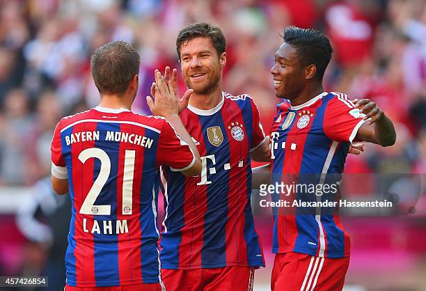 Xabi Alonso of Bayern Muenchen celebrates with Philipp Lahm and David Alaba of Bayern Muenchen after scoring their second goal during the Bundesliga...