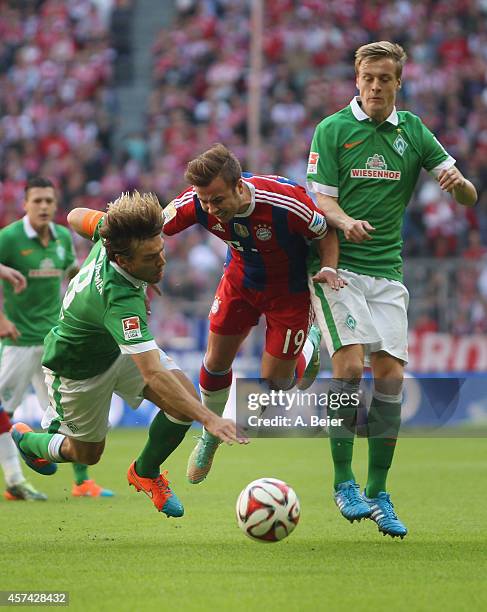 Mario Goetze of Bayern Muenchen is tackled by Clemens Fritz and Felix Kroos of Werder Bremen during the Bundesliga match between FC Bayern Muenchen...