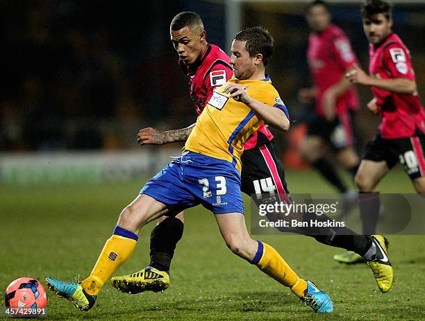 Jamie McGuire of Mansfield holds off pressure from Jonson Clarke-Harris of Oldham during the FA Cup Second Round Replay match between Mansfield Town...