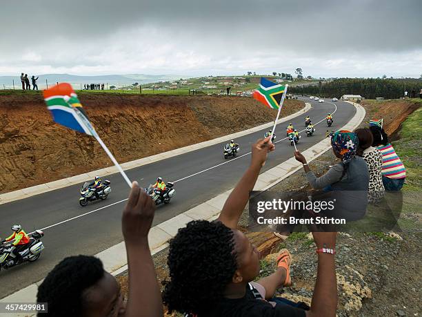 Women wave flags at the Nelson Mandela funeral procession, Qunu, South Africa, 14 December 2014. An icon of democracy, Mandela was buried at his...