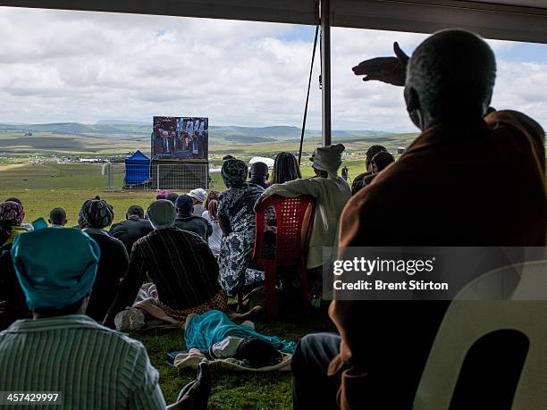 Local people watches the Mandela funeral service on a large television situated on a hilltop overlooking the service in the valley below, Qunu, South...