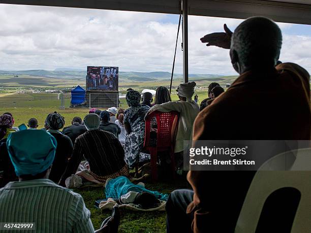 Local people watches the Mandela funeral service on a large television situated on a hilltop overlooking the service in the valley below, Qunu, South...