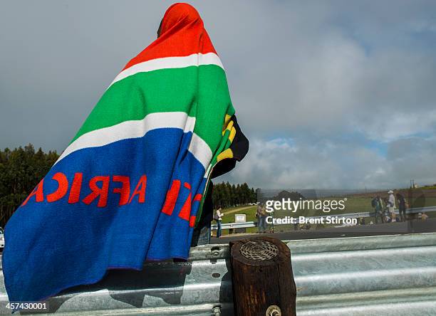 Man wearing a blanket in the South African colors waits for the Nelson Mandela funeral procession to pass, Qunu, South Africa, 14 December 2014. An...