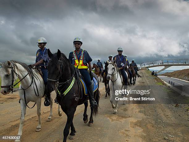 Police horse patrol monitors the area as they wait for the Nelson Mandela funeral procession to pass, Qunu, South Africa, 14 December 2014. An icon...