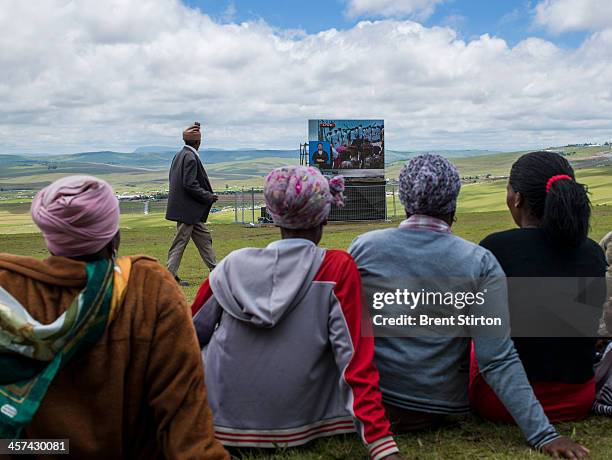 Local people watches the Mandela funeral service on a large television situated on a hilltop overlooking the service in the valley below, Qunu, South...