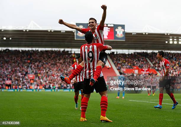 Graziano Pelle of Southampton is congratulated by Dusan Tadic as he scores their fifth goal during the Barclays Premier League match between...