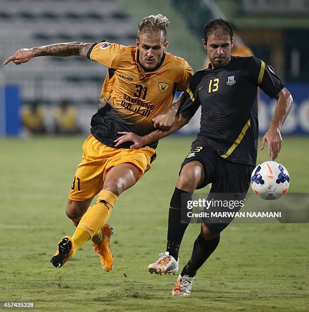 Arbil FC's defender Ahmed Mohammed Hussein fights for the ball with Qadsia SC's forward Danijel Subotic during the 2014 AFC Cup final football match...