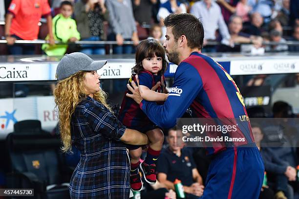 Gerard Pique of FC Barcelona passes his son Milan to his wife Shakira during the La Liga match between FC Barcelona and SD Eibar at Camp Nou on...