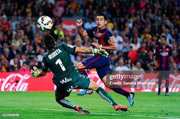 Xavi Hernandez of FC Barcelona scores the opening goal past Xabi Irureta of SD Eibar during the La Liga match between FC Barcelona and SD Eibar at...