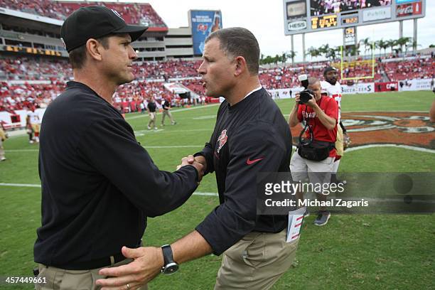 Head Coach Jim Harbaugh of the San Francisco 49ers shakes hands with Head Coach Greg Schiano of the Tampa Bay Buccaneers following the game at...