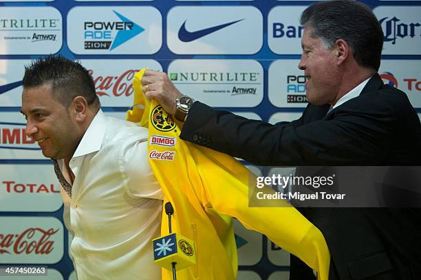 Mexican former player Ricardo Pelaez helps Antonio Mohamed to wear an America's jacket during Mohamed's presentation as new coach of Mexican team...