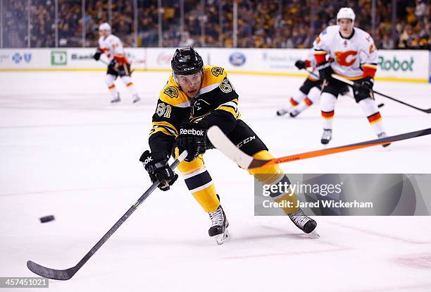 Craig Cunningham of the Boston Bruins tries to stop a pass in his NHL debut against the Calgary Flames in the first period at TD Garden on December...