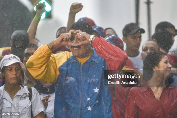Venezuelan President Nicolas Maduro makes a heart gesture after he delivers a speech about claims of lawmaker Robert Serra murder during a...