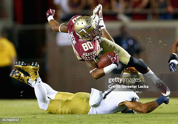 Rashad Greene of the Florida State Seminoles is hit by Matthias Farley of the Notre Dame Fighting Irish during their game at Doak Campbell Stadium on...