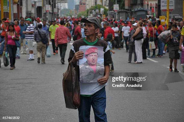 Government supporters march against terrorism and for the peace in Caracas, on October 18, 2014. They hold banner of Hugo Chavez during the march.