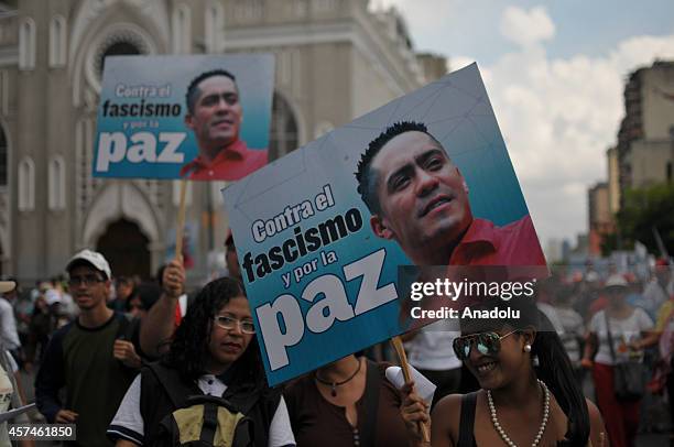 Government supporters march against terrorism and for the peace in Caracas, on October 18, 2014. They hold banner of killed parliamentarian Robert...