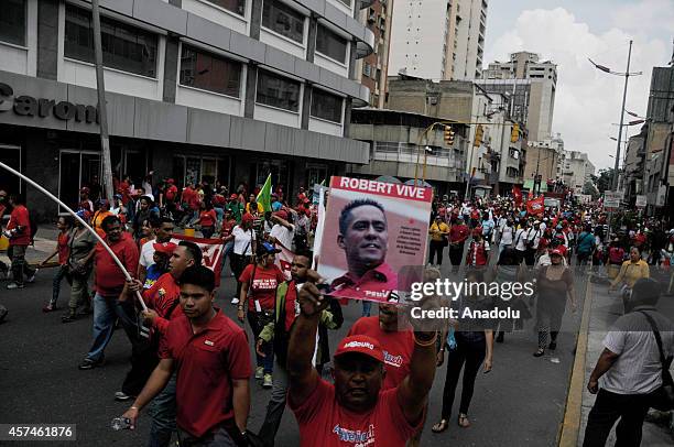 Government supporters march against terrorism and for the peace in Caracas, on October 18, 2014. They hold banner of killed parliamentarian Robert...