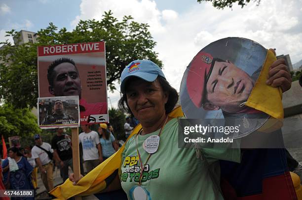 Government supporters march against terrorism and for the peace in Caracas, on October 18, 2014. They hold banner of killed parliamentarian Robert...