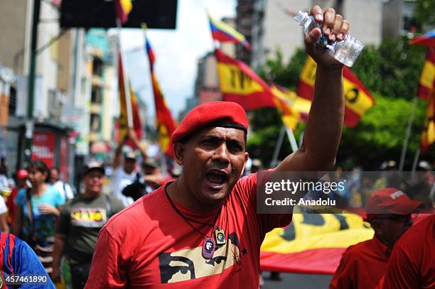 Government supporters march against terrorism and for the peace in Caracas, on October 18, 2014. They hold banner of killed parliamentarian Robert...