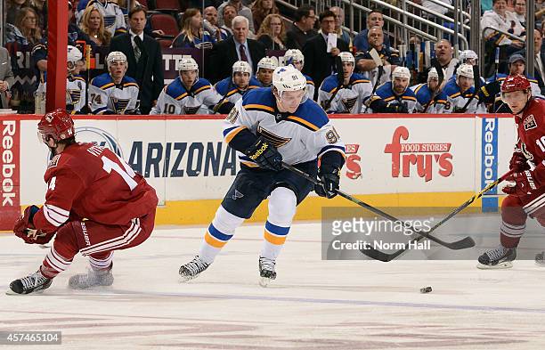 Vladimir Tarasenko of the St Louis Blues skates with the puck around the defense of Joe Vitale of the Arizona Coyotes during the third period at Gila...