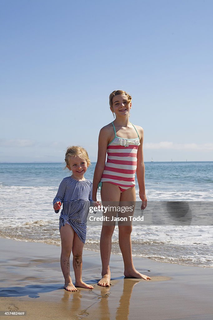 Sisters holding hands on beach