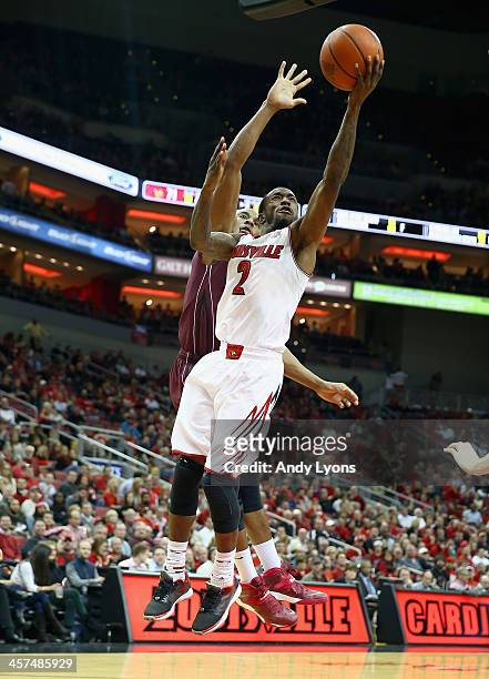 Russ Smith of the Louisville Cardinals shoots the ball while defended by Keith Pickens of the Missouri State Bears during the game at KFC YUM! Center...