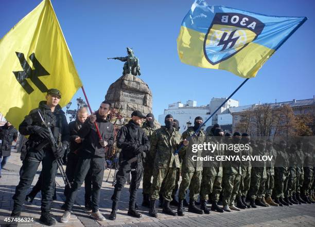 Servicemen of the pro-Ukrainian Azov battalion attend an oath ceremony in Kiev on October 19, 2014. New members of the battalion leave Kiev after the...