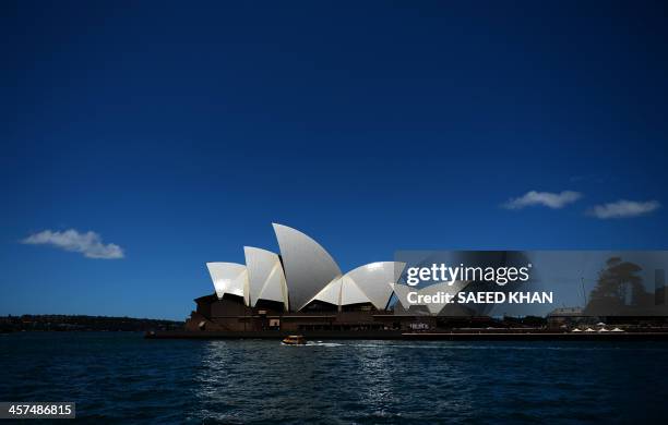 The sun light reflects on the sails of Sydney's iconic land mark Opera House as a water taxi passes by on December 18, 2013. Australia's central bank...