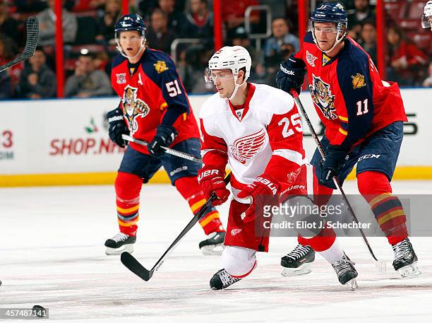 Jonathan Huberdeau of the Florida Panthers skates for possession against Cory Emmerton of the Detroit Red Wings at the BB&T Center on December 10,...