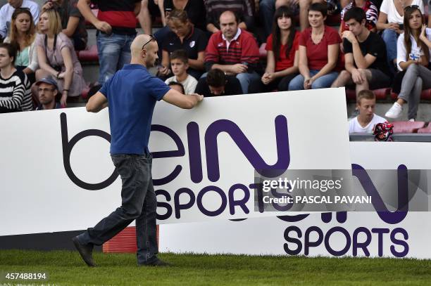 Man carries an advertising board of the sports TV channel Bein sports before the European Rugby Champions Cup match between Toulouse and Montpellier...
