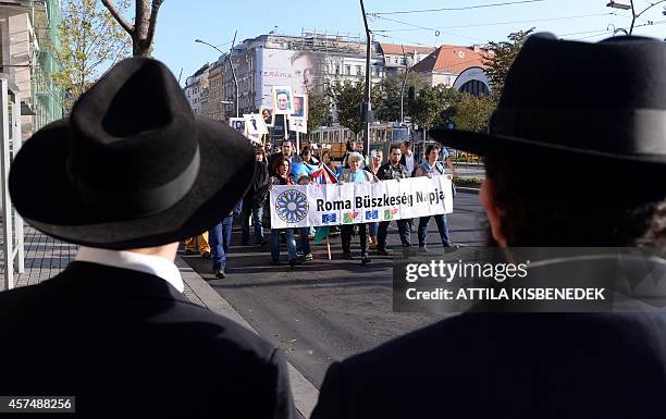 Jewish people watch local Roma and their sympathizers marching with a banner reading "Roma Pride Day" to demonstrate against racism and...