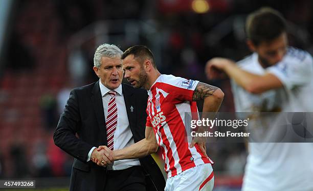 Stoke manager Mark Hughes congratulates Phil Bardsley after the Barclays Premier League match between Stoke City and Swansea City at Britannia...