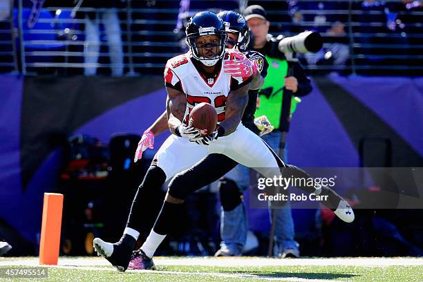 Cornerback Robert Alford of the Atlanta Falcons makes a second quarter interception while battling wide receiver Torrey Smith of the Baltimore Ravens...