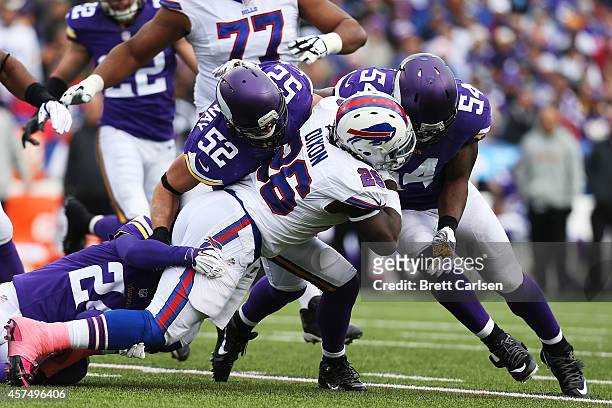 Anthony Dixon of the Buffalo Bills is tackled by Captain Munnerlyn of the Minnesota Vikings, Chad Greenway of the Minnesota Vikings and Jasper...
