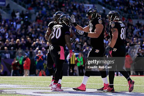 Running back Bernard Pierce of the Baltimore Ravens is congratulated by teammates after scoring a touchdwon in the second quarter of a game against...