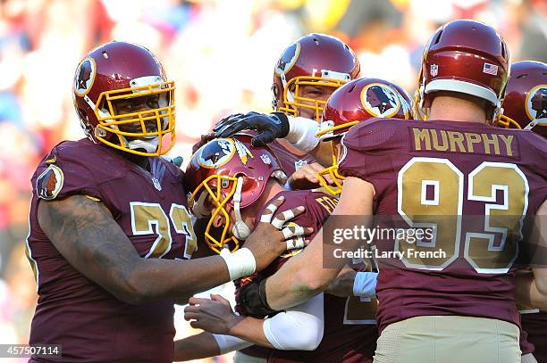 Kai Forbath of the Washington Redskins is congratulated by teammates after kicking the game winning field goal against the Tennessee Titans at FedEx...