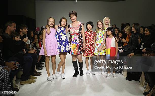 Designer Peini Yang walks the runway with models during the Aria Children's Clothing preview at petitePARADE / Kids Fashion Week at Bathhouse Studios...