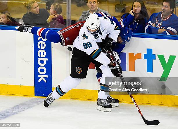 Rick Nash of the New York Rangers fights for the puck with Brent Burns of the San Jose Sharks in the first period at Madison Square Garden on October...