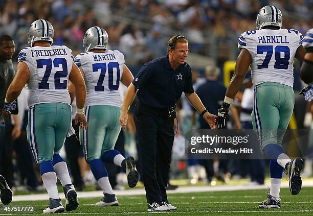 Head coach Jason Garrett of the Dallas Cowboys congratulates Jermey Parnell of the Dallas Cowboys as he and Travis Frederick of the Dallas Cowboys...