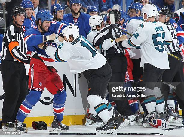 Tanner Glass of the New York Rangers and Andrew Desjardins of the San Jose Sharks fight in the third period at Madison Square Garden on October 19,...