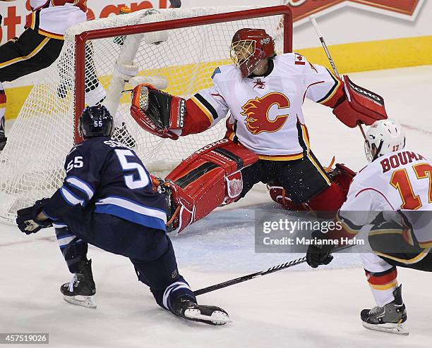 Mark Scheifele of the Winnipeg Jets scores against Jonas Hiller of the Calgary Flames in first period action in an NHL game at the MTS Centre on...