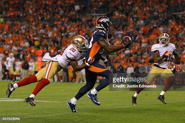 Wide receiver Demaryius Thomas of the Denver Broncos catches a pass for a third quarter touchdown under coverage by cornerback Perrish Cox and strong...