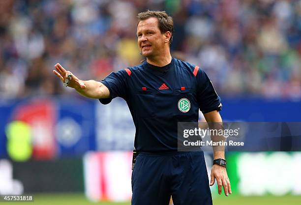 Referee Peter Sippel gestures during the Bundesliga match between Hamburger SV and 1899 Hoffenheim at Imtech Arena on October 19, 2014 in Hamburg,...