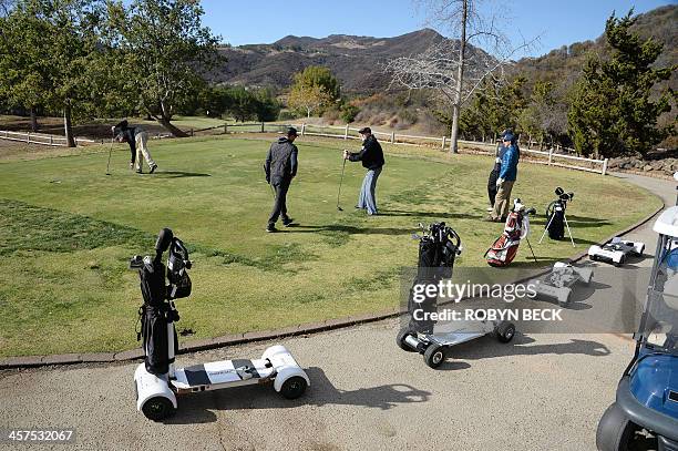 GolfBoards are seen beside the green as players prepare to tee off during a golf tournament at the Malibu Golf Club in Malibu, California December 9,...