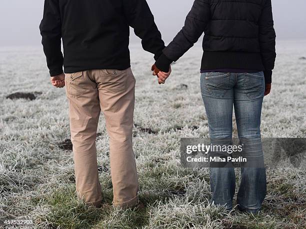 couple holding hands outside in thick fog - lower ストックフォトと画像